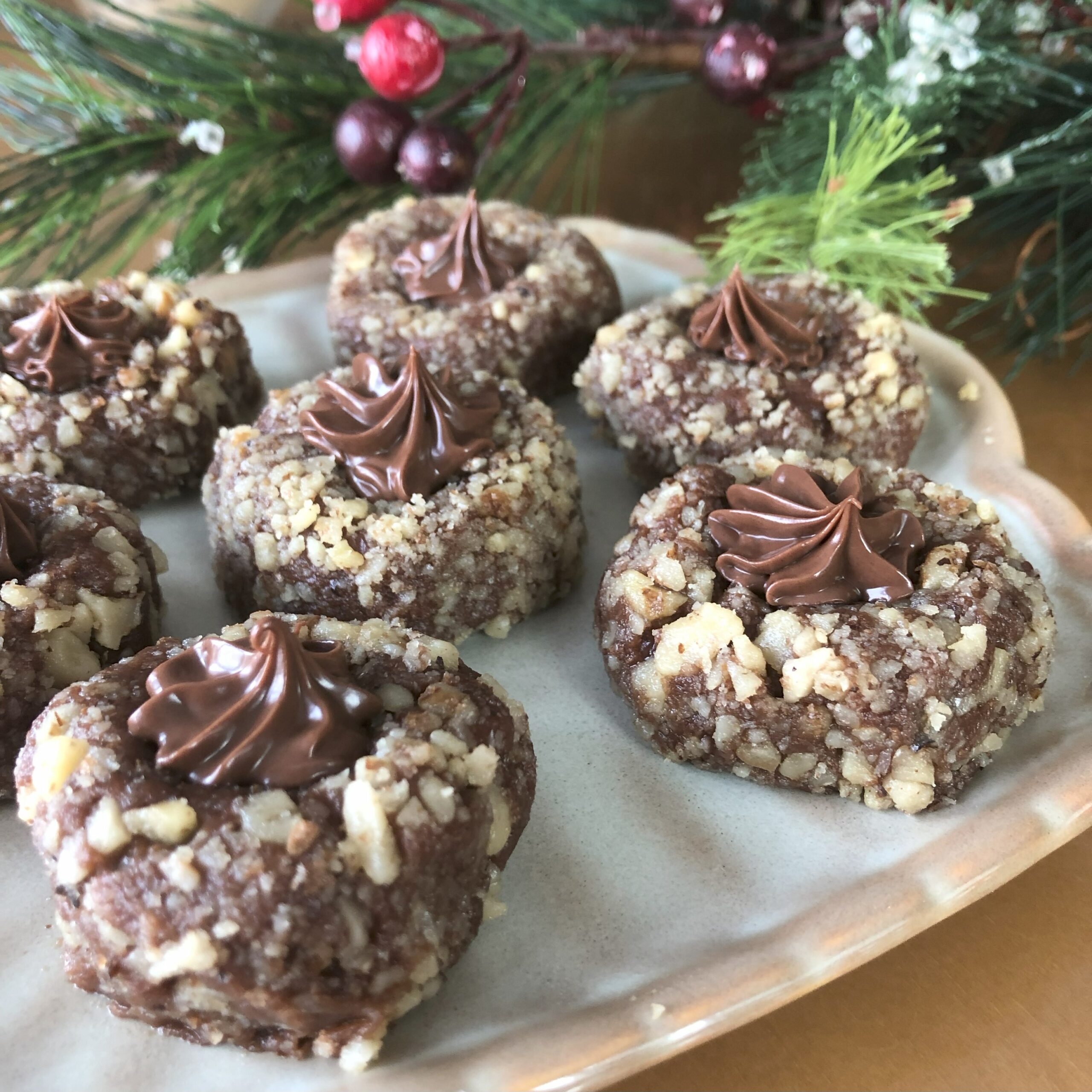 Nutty Nests Cookies displayed on a plate on Christmas decorated table.